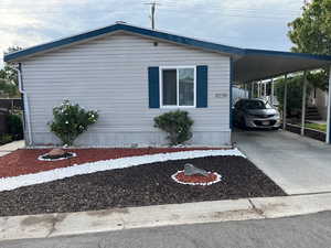 View of front of home with driveway and a carport
