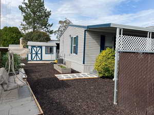 View of side of home with a garden and a shed