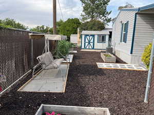 View of yard featuring a vegetable garden and a shed