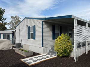 View of side of home featuring a vegetable garden and covered porch