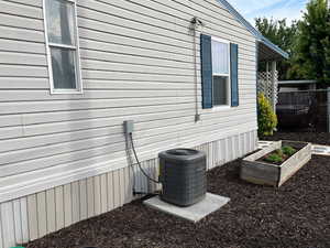 View of property exterior featuring a garden and a cooling unit