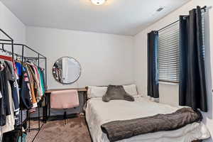 Carpeted bedroom featuring a textured ceiling