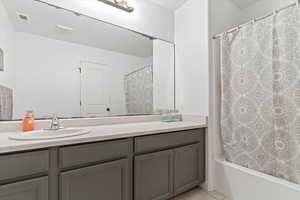 Bathroom featuring vanity, light tile patterned floors, and shower / tub combo