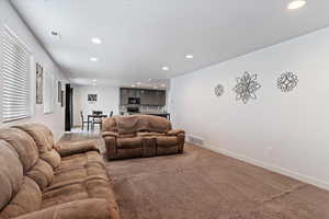 Carpeted living room featuring recessed lighting