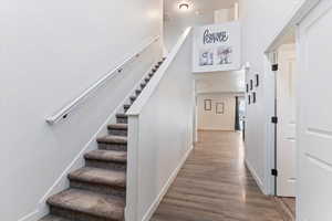 Staircase with wood finished floors and baseboards