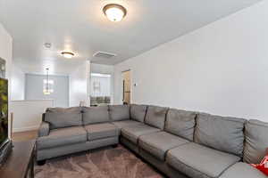 Living area featuring carpet floors and a textured ceiling