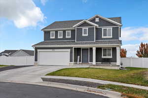View of front facade featuring covered porch, concrete driveway, a garage, board and batten siding, and a shingled roof