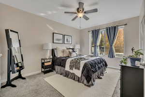 Primary bedroom with walk-in closet, carpet & fan