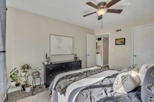 Primary bedroom with walk-in closet, carpet & fan