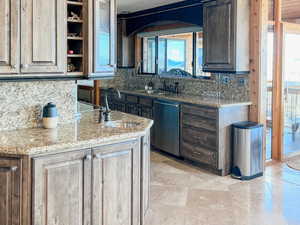 Kitchen featuring decorative backsplash, light stone counters, wood ceiling, dishwasher, and open shelves