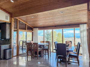Dining room with wooden ceiling, plenty of natural light, and vaulted ceiling