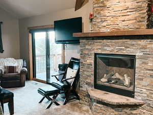 Carpeted living area featuring a fireplace