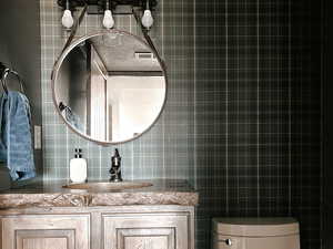 Half bath featuring tile walls, vanity, and tile patterned flooring