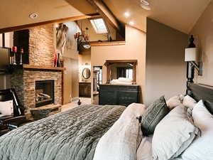 Bedroom with beamed ceiling, high vaulted ceiling, a fireplace, and recessed lighting