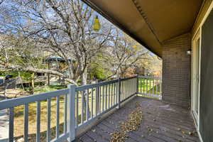 Wooden deck with a lawn and view of scattered trees
