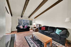 Living area featuring beam ceiling, a textured ceiling, and carpet floors