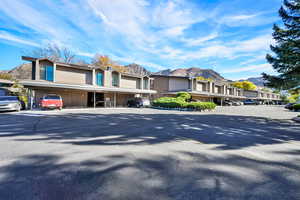 View of building exterior with a mountain view, covered parking, and a residential view