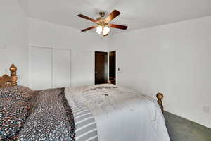 Carpeted bedroom featuring a closet and a ceiling fan