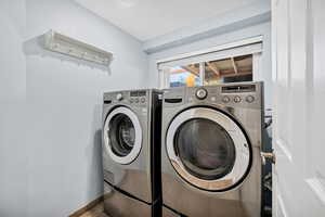 Laundry area with baseboards and washing machine and dryer