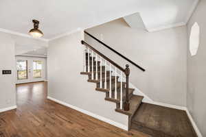 Stairs with crown molding, hardwood / wood-style flooring, and french doors