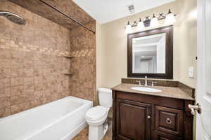 Bathroom featuring vanity, shower / bath combination, and light tile patterned floors