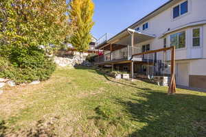 View of grassy yard with a wooden deck