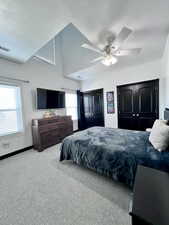 Carpeted bedroom featuring ceiling fan and a textured ceiling