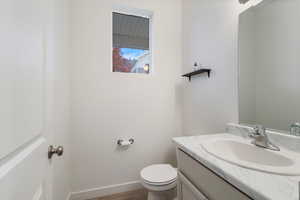 Half bath with vanity and dark wood-style floors