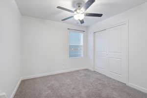 Unfurnished bedroom with carpet floors, ceiling fan, and a closet
