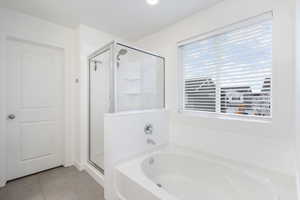 Full bathroom with a garden tub, light tile patterned floors, and a shower stall