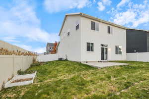 Rear view of house featuring a patio area, a fenced backyard, stucco siding, and a vegetable garden