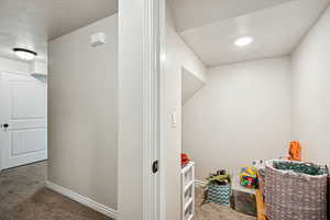 Recreation room featuring carpet floors and a textured ceiling