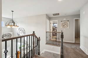 Staircase featuring carpet and a chandelier