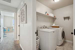 Laundry area featuring separate washer and dryer and baseboards