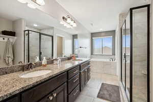 Full bathroom with double vanity, light tile patterned floors, a garden tub, and a shower stall