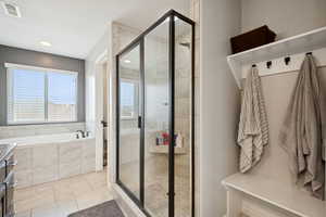 Bathroom with light tile patterned floors, a bath, a shower stall, and vanity