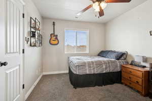 Carpeted bedroom with baseboards and ceiling fan