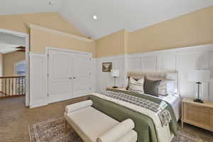Carpeted bedroom with a closet, high vaulted ceiling, a decorative wall, and recessed lighting