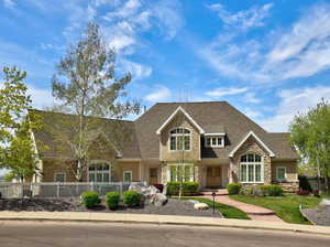 Craftsman house featuring stone siding and roof with shingles
