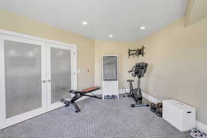 Exercise room with french doors, recessed lighting, and carpet
