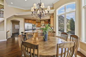 Dining room featuring arched walkways, dark wood-style flooring, ornamental molding, recessed lighting, and a mountain view