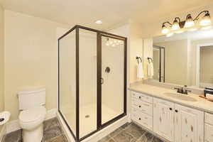 Full bath with vanity, a shower stall, and recessed lighting