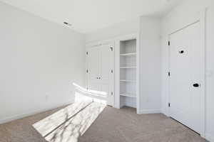 Bedroom 2 featuring light carpet and a closet