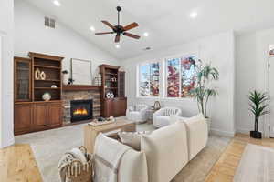 Living room 2 with light wood-style flooring, a stone fireplace, recessed lighting, high vaulted ceiling, and a ceiling fan