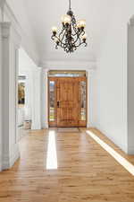 Foyer featuring hardwood / wood-style floors and a chandelier
