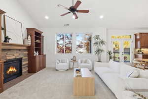 Living room 2 with vaulted ceiling, carpet flooring, French doors, a ceiling fan, and a fireplace
