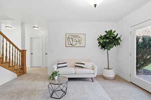 Tiled living area with stairway and baseboards