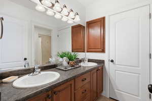 Basement Bathroom with double vanity, a shower with curtain, and light tile patterned floors