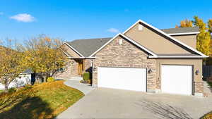 View of front of home with concrete driveway, a garage, and stucco siding