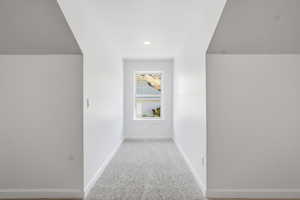 Additional living space above the garage with light colored carpet and recessed lighting